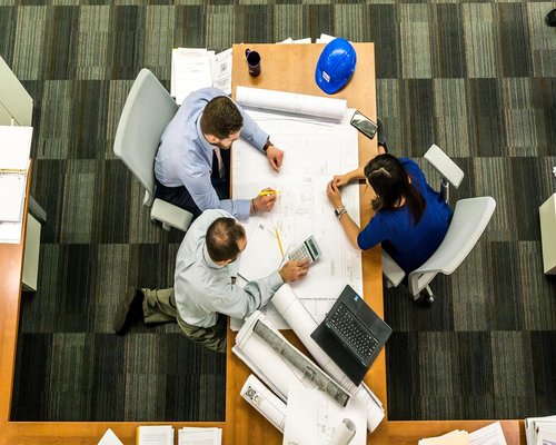 Group of diverse young professionals discussing project at a table